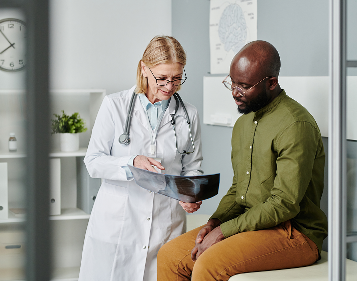 A healthcare provider reviews an X-ray with a patient.